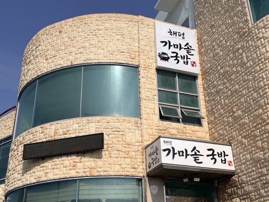 돌 외벽 건물과 «해평 가마솥 국밥» 붓글씨 간판